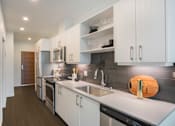 Thumbnail 1 of 24 - a kitchen with white cabinets and stainless steel appliances