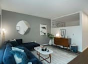 Thumbnail 7 of 24 - a living room with a blue couch and a white coffee table