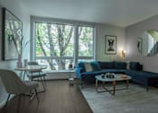 Thumbnail 8 of 24 - a living room with a blue couch and a table and a large window