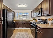 Thumbnail 9 of 24 - a kitchen with black appliances and wooden cabinets
