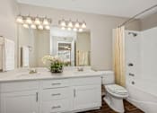 Thumbnail 2 of 24 - a bathroom with a large mirror and a toilet and a sink
