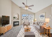 Thumbnail 8 of 24 - a living room with a ceiling fan and a tv