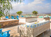 Thumbnail 10 of 21 - A patio with a couch and a table with a view of the mountains.