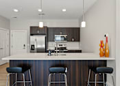 Thumbnail 5 of 53 - A modern kitchen with a bar stool.
