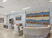 Thumbnail 17 of 26 - a waiting room with couches and chairs and paintings on the wall
