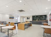 Thumbnail 23 of 26 - a dining room with tables and chairs and a blackboard in a classroom