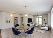 Thumbnail 1 of 18 - a living room with a table and chairs and a couch