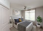 Thumbnail 4 of 18 - an open bedroom with a bed and a ceiling fan