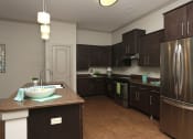 Thumbnail 6 of 18 - a large kitchen with stainless steel appliances and dark wood cabinets