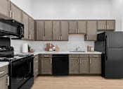 Thumbnail 7 of 8 - A modern kitchen with black appliances and wooden cabinets.