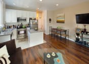 Thumbnail 21 of 64 - Apartment living room with kitchen and stainless steel appliances