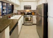 Thumbnail 46 of 64 - Apartment kitchen with built-in cabinets and stainless steel appliances