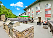 Thumbnail 8 of 23 - A patio with a stone barbecue and chairs.