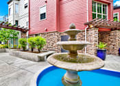 Thumbnail 10 of 23 - A fountain in the middle of a pool surrounded by a house.