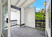 Thumbnail 20 of 33 - A patio with a white door and a black railing.