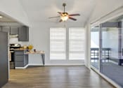 Thumbnail 28 of 33 - A kitchen with a ceiling fan and a dining table with chairs.