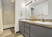 Thumbnail 22 of 33 - A bathroom with a sink, mirror, and shower.