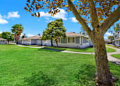 Thumbnail 12 of 31 - Community courtyard with mature trees and walking paths at Coventry Square Apartments, California