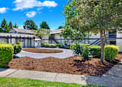 Thumbnail 11 of 33 - A building with a landscaped front yard and a tree.