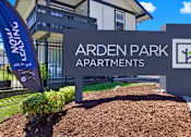 Thumbnail 7 of 33 - A sign for Arden Park Apartments is shown in front of a building.