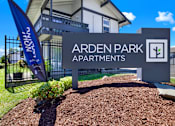 Thumbnail 4 of 33 - A sign for Arden Park Apartments is displayed in front of a building.