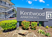 Thumbnail 9 of 21 - A sign for Kentwood Apartments is displayed in front of a building.