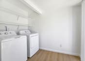 Thumbnail 29 of 31 - Laundry room with white washer and dryer at Coventry Square Apartments, Upland, California