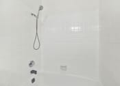 Thumbnail 22 of 31 - Bathtub with handheld shower and tile surround at Coventry Square Apartments, California, 97186