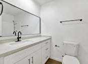 Thumbnail 23 of 31 - Modern bathroom with dual sink vanity and towel bar at Coventry Square Apartments, Upland, California