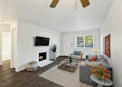 Thumbnail 16 of 21 - A living room with a fireplace and a flat screen TV mounted on the wall.