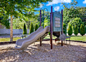 Thumbnail 8 of 21 - A playground with a slide and a swing set.
