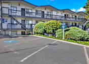 Thumbnail 7 of 21 - A parking lot in front of a building with a blue sign.