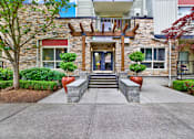 Thumbnail 6 of 23 - A stone building with a wooden entrance and a glass door.