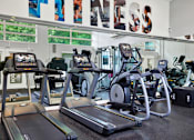 Thumbnail 15 of 23 - A gym with treadmills and exercise bikes.