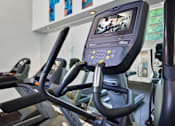Thumbnail 21 of 23 - A row of treadmills in a gym with a monitor on the front.