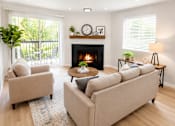 Thumbnail 6 of 25 - A living room with a fireplace and two couches.