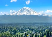 Thumbnail 5 of 21 - A snow-capped mountain with a town in the foreground.