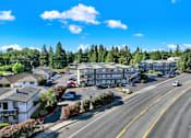 Thumbnail 2 of 21 - A street view of a residential area with houses and a parking lot.