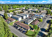 Thumbnail 4 of 21 - A large building complex with a parking lot in front.