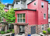 Thumbnail 5 of 23 - A red building with a black door and windows.