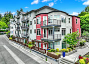 Thumbnail 1 of 23 - A row of multi-story apartment buildings with balconies and flower pots on the steps.