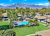 Thumbnail 14 of 31 - Aerial view of pool area with palm trees and mountains at Coventry Square Apartments, Upland, CA 97186