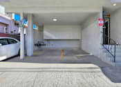 Thumbnail 12 of 25 - A parking garage with a white car parked on the left side.at Federal Apartments, Los Angeles