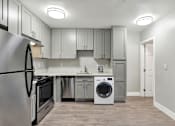 Thumbnail 7 of 25 - A modern kitchen with a stainless steel refrigerator, microwave, dishwasher, and oven.at Federal Apartments, California, 90025