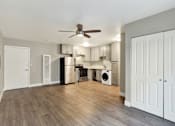 Thumbnail 6 of 25 - A kitchen with a white ceiling fan and wooden floors.at Federal Apartments, California