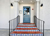 Thumbnail 16 of 16 - A staircase with a blue door and black railings.at Barton Apartments, California