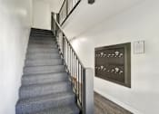 Thumbnail 12 of 16 - A staircase with a grey carpeted runner and a metal railing.at Barton Apartments, Los Angeles, CA
