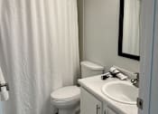 Thumbnail 8 of 25 - A white toilet sits next to a white sink in a bathroom.
