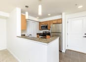 Thumbnail 39 of 52 - a kitchen with a granite counter top and a stainless steel refrigerator  at Delano, Redmond, 98052