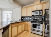 Thumbnail 26 of 52 - a kitchen with stainless steel appliances and wooden cabinets  at Delano, Redmond Washington
